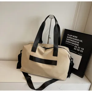 Large capacity canvas travel duffel bag detail, khaki gym bag with black shoulder straps.