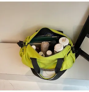 Detail view of fluorescent green fitness duffel bag showing interior capacity and storage layout.