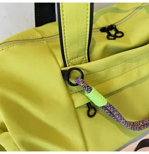 Close-up detail of fluorescent green fitness bag showing waterproof fabric and sturdy zippers.