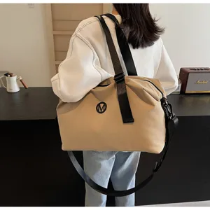 Detailed lifestyle view of a large capacity beige casual travel duffel bag with shoulder strap.