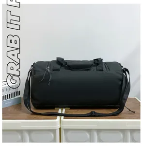 Detail view of black travel duffel bag showing durable fabric and adjustable shoulder strap.