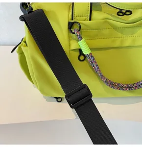 Close up detail of neon green gym duffel bag featuring wide black adjustable strap.