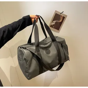 Durable gray travel duffel bag for men and women, waterproof sports gym bag with shoulder strap.