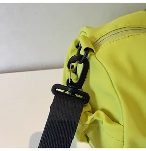 Strap connector detail of neon green gym bag showing sturdy black hook and durable fabric.