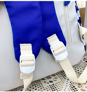 Primo piano della cinghia dello zaino e della fibbia in plastica con dettagli di finitura.