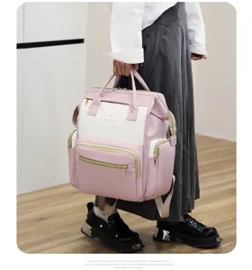 Primer plano detallado de la mochila cambiador multifuncional rosa y blanca con gran espacio.