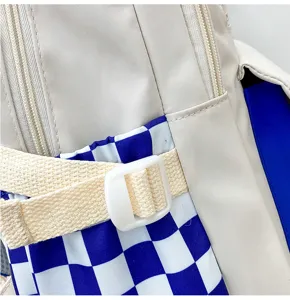 Primo piano dettagliato dello zaino alla moda con cerniera, cinghie e motivo a quadri.