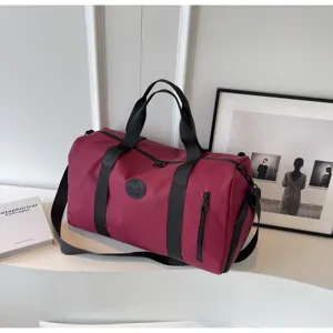 Detail view of the maroon multi-functional travel duffel bag showing quality zipper and straps.
