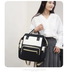 Mochila para pañales de gran capacidad con compartimentos multifuncionales y diseño blanco y negro.