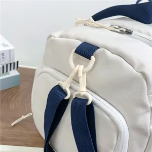 White gym duffel bag for sports and travel, featuring durable straps and buckle details.