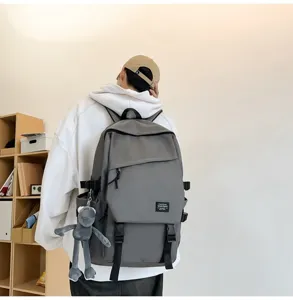 Grauer großer lässiger Schulrucksack mit süßem Plüschanhänger für den täglichen Arbeitsweg