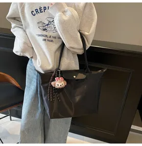 Detailansicht der lässigen großen schwarzen Schultertasche mit klassischem Überschlag und Knopf.