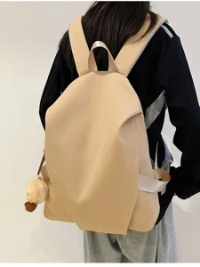 Vista dettagliata dello zaino kaki casual minimalista con ciondolo in peluche, spallacci larghi.