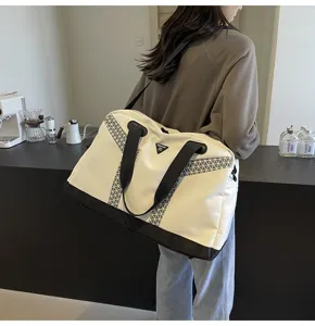 Details of the large capacity travel duffel bag with geometric reflective straps and handles.