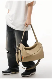 Detailed view of casual khaki crossbody fitness travel bag showing texture and handle structure.