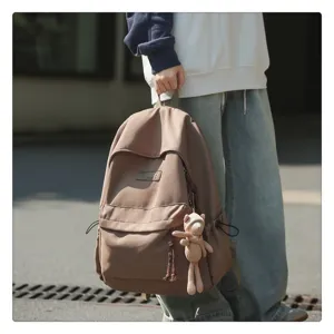 Detailansicht des lässigen braunen Studentenrucksacks mit Anhänger, minimalistischer Schulranzen.