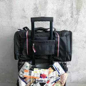Large capacity black travel duffel bag with trolley sleeve and shoe compartment for sports.