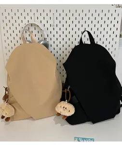 Dettaglio zaino casual minimalista, elegante borsa da studente con ciondolo in peluche.