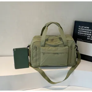 Detailed view of large capacity green travel duffel bag with shoulder strap and zipper pockets.