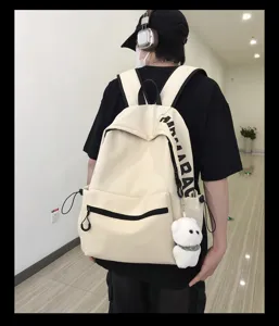 Casual minimalist canvas backpack for women and students with cute bear pendant and spacious design.