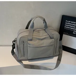 Gray large capacity gym duffel bag with shoulder strap and multiple zipper pockets detail view