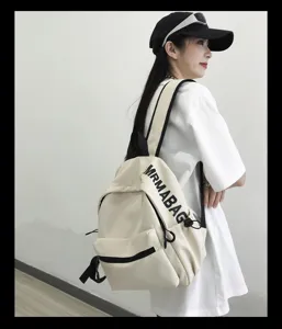 Detailed shot of a minimalist casual beige backpack worn by a model, showcasing design.