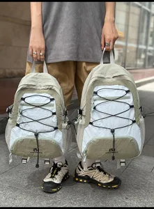 Dettaglio in primo piano dello zaino con cordino elastico esterno e comode tasche laterali in rete.
