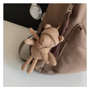 Niedlicher Strickbär Anhänger Detail an einem schicken braunen Rucksack für den Alltag.