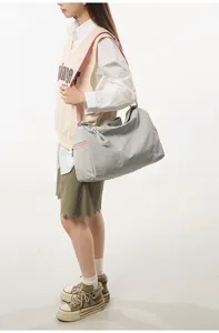 Side view detail of the trendy color-blocking travel yoga gym duffel bag with pink straps.