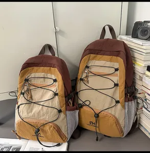 Vista dettagliata dello zaino da esterno colorblock con cordino elastico e tasche.