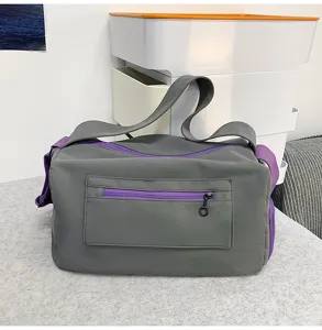 Detail view of grey and purple yoga gym duffle bag showing zipper pocket and durable strap.