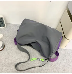 Detail view of the stylish gray gym duffel bag featuring purple accents and shoulder strap.
