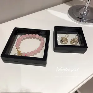 Detail de boite de rangement de bijoux en film PE transparent avec bracelet et boucles d'oreilles.