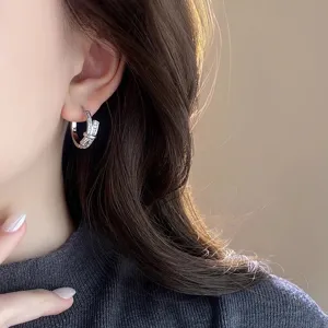 Elegant silver cubic zirconia bow hoop earring detail view, delicate sparkly crystal jewelry.