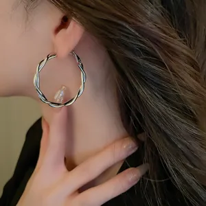 Twisted geometric metal hoop earrings for women, stylish versatile daily ear jewelry accessory.