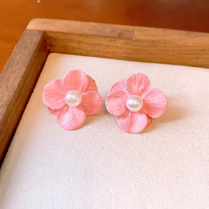 Delicate pink flower earrings with a central pearl detail, elegant floral jewelry design for women.