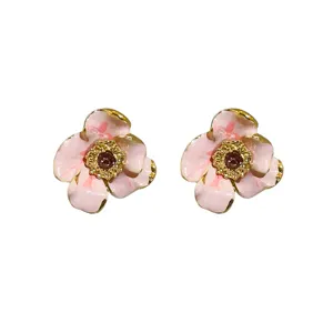 Pink enamel flower stud earrings with sparkling rhinestones and elegant gold edge design.