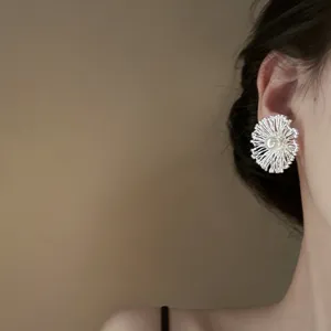 Close-up detail of the elegant floral pearl stud earring showing delicate texture and craftsmanship.