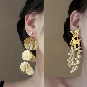 Elegant gold plated statement earrings for women, featuring chic leaf and pearl drop designs.