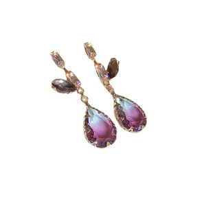 Eleganti orecchini pendenti a goccia in zirconia viola sfumata con dettagli dorati.