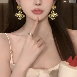 Detailed view of trendy gold floral drop earrings, elegant fashion jewelry for women.
