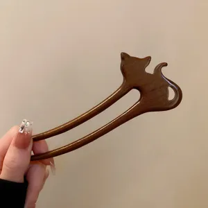 Detailed close-up of a vintage wooden hair fork with cute animal silhouette design.