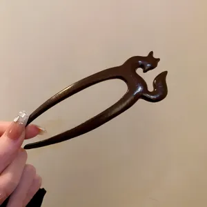 Wooden hair fork detail view, showcasing the elegant animal carved design and smooth dark wood finish.