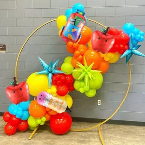 Dettaglio dell'arco di palloncini per la scuola con mela, matita e zaino in alluminio.