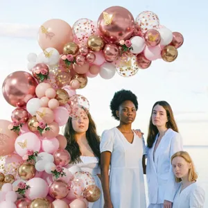 Pink gold butterfly balloon garland detail shot, showing party arch setup and floral decor.