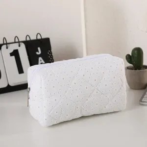 Detalle de bolso de cosméticos acolchado blanco, bolsa de maquillaje bordada suave, neceser.