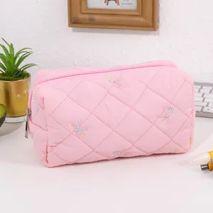 Pink quilted cosmetic bag with cute embroidered bows, portable travel makeup pouch for daily use.