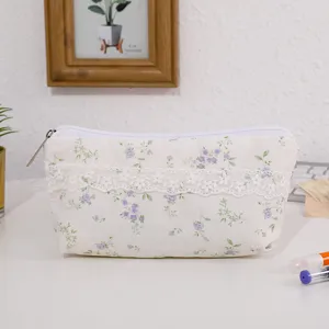 Primo piano di una dolce custodia per matite floreale con delicato pizzo bianco e chiusura.