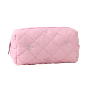 Close-up detail of the pink quilted cosmetic bag featuring cute embroidered bows and zipper.
