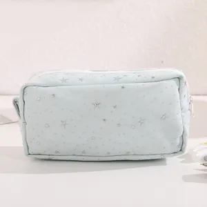 Dettaglio ravvicinato dell'astuccio verde chiaro con ricamo di stelle lucide e cerniera bianca.
